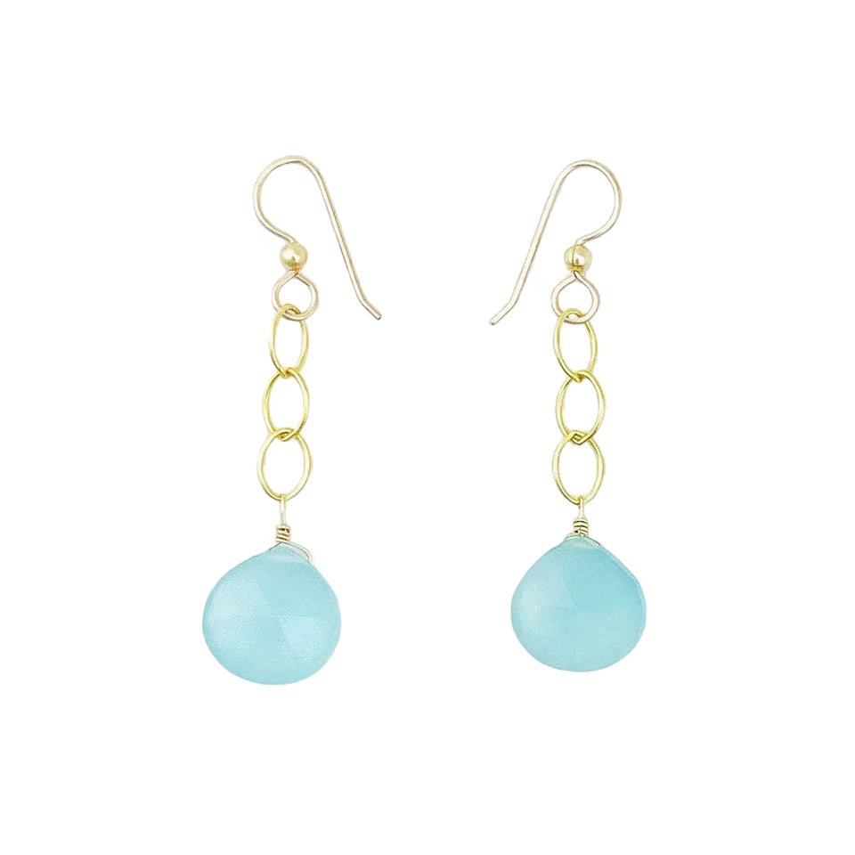 A pair of gold dangle earrings with a light blue teardrop-shaped stone pendant, shown on a white background.