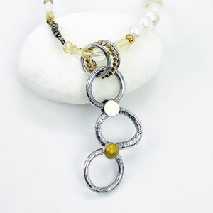 Necklace with circular pendant and beads on a white background