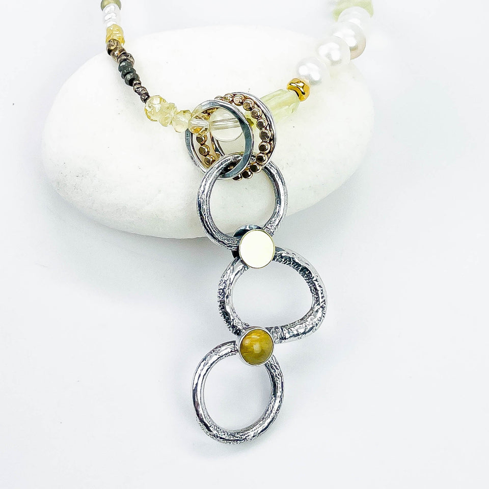 Necklace with circular pendant and beads on a white background