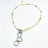 Necklace with circular pendant and beaded chain on a white background