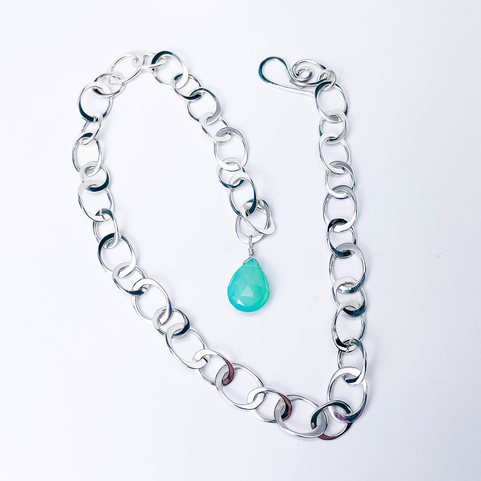 Silver chain chunky sterling with a chalcedony teardrop charm on a white background
