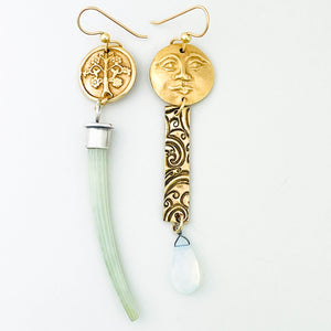 Bronze earring with a clear translucent gemstone (opalite) next to a ruler on a white background
