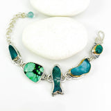 A silver chain bracelet featuring five irregular-shaped green and blue marbled gemstones, displayed on a white background with a checkerboard transparency pattern.