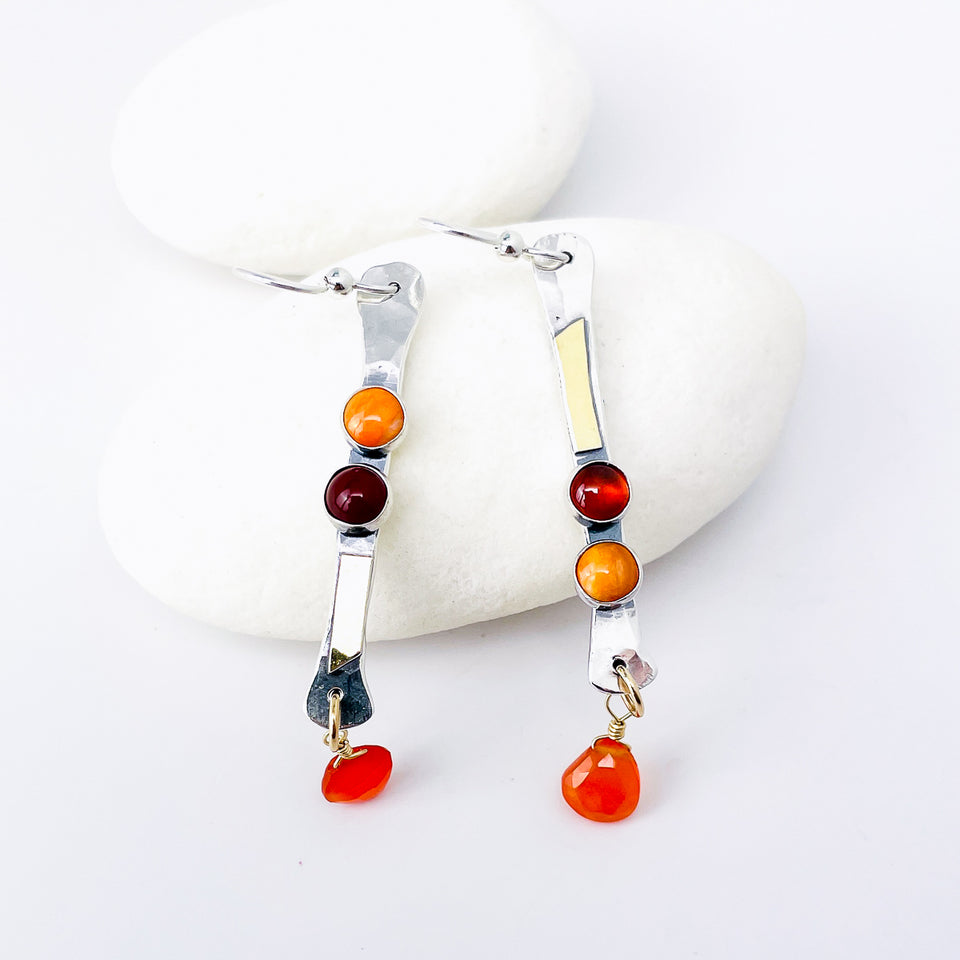Pair of earrings with colorful beads and gold accents on white background