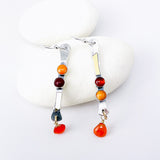 Pair of earrings with colorful beads and gold accents on white background